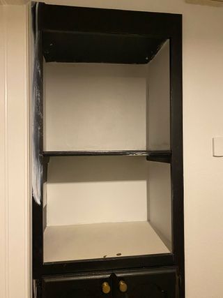 inside of black bare cabinet pre-makeover