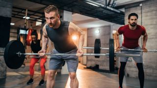 Group of people performing the barbell row