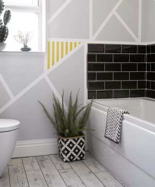 A modern monochrome bathroom with bathtub against a wall