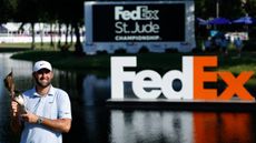 Scottie Scheffler holds the FedEx St. Jude Championship trophy