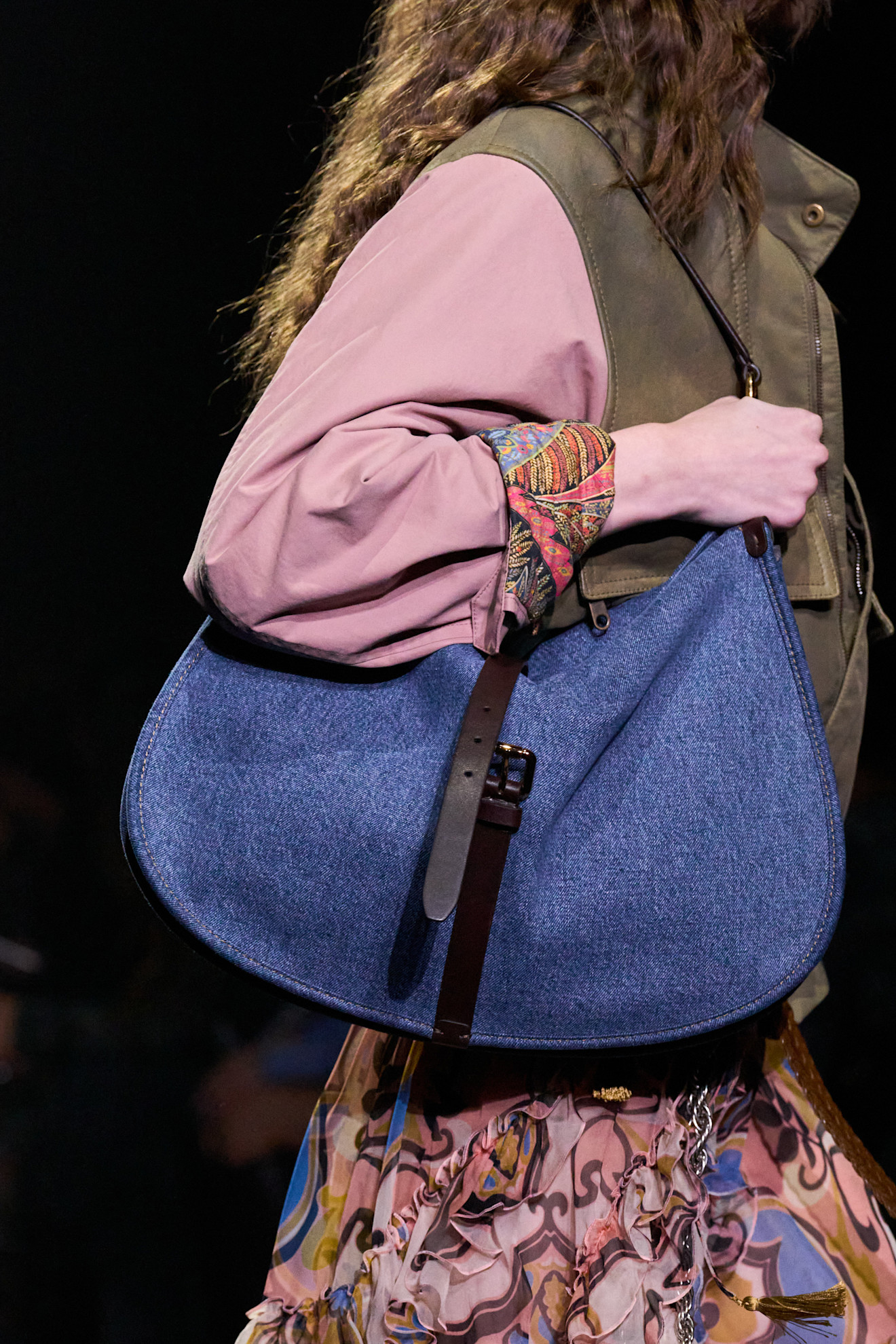 A Etro runway model wearing a denim bag.