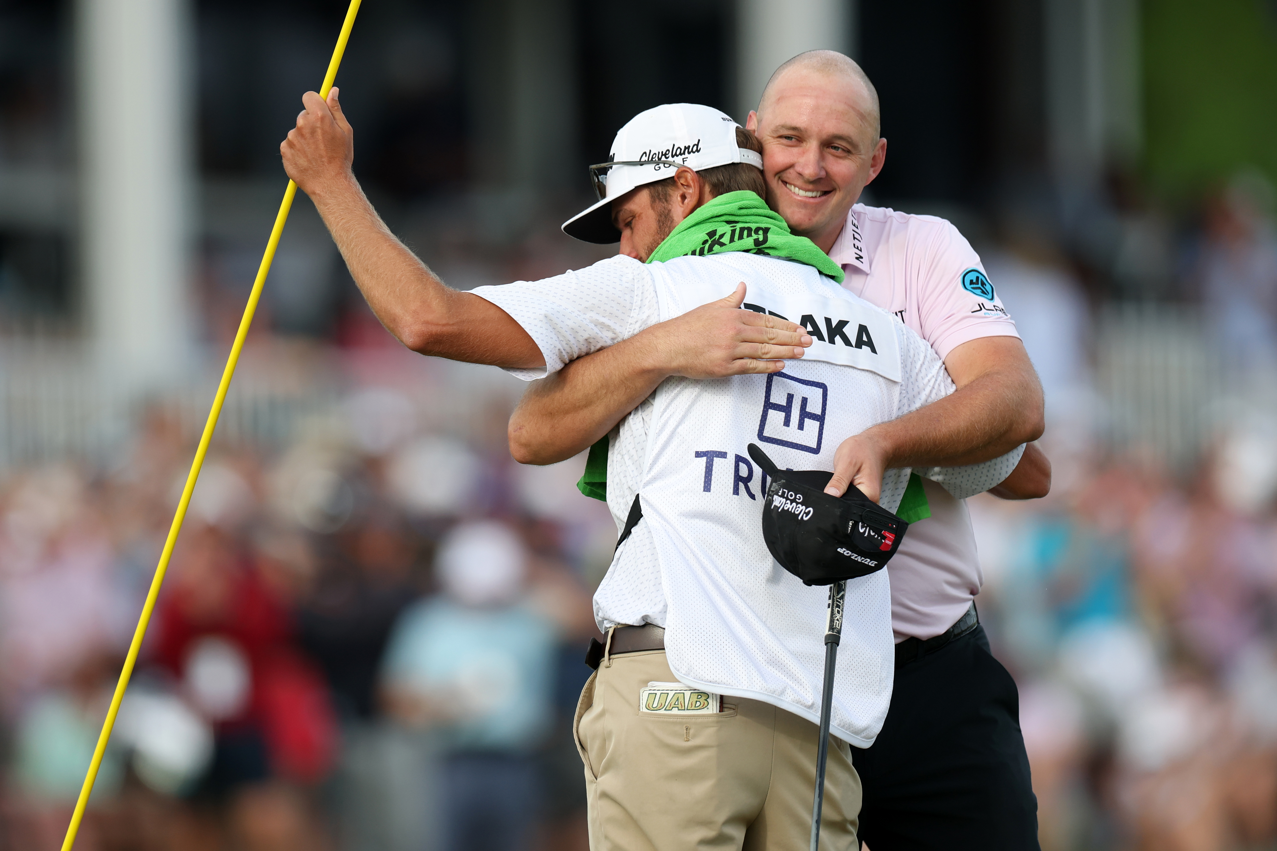 Sepp Straka hugs his caddie on the 18th green