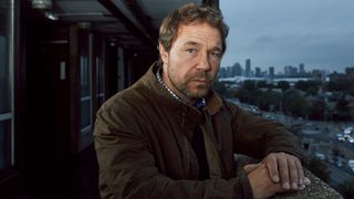 Stephen Graham poses outside a row of flats as Matthew Collins for The Walk-in