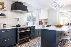 A modern kitchen with dark blue cabinetry
