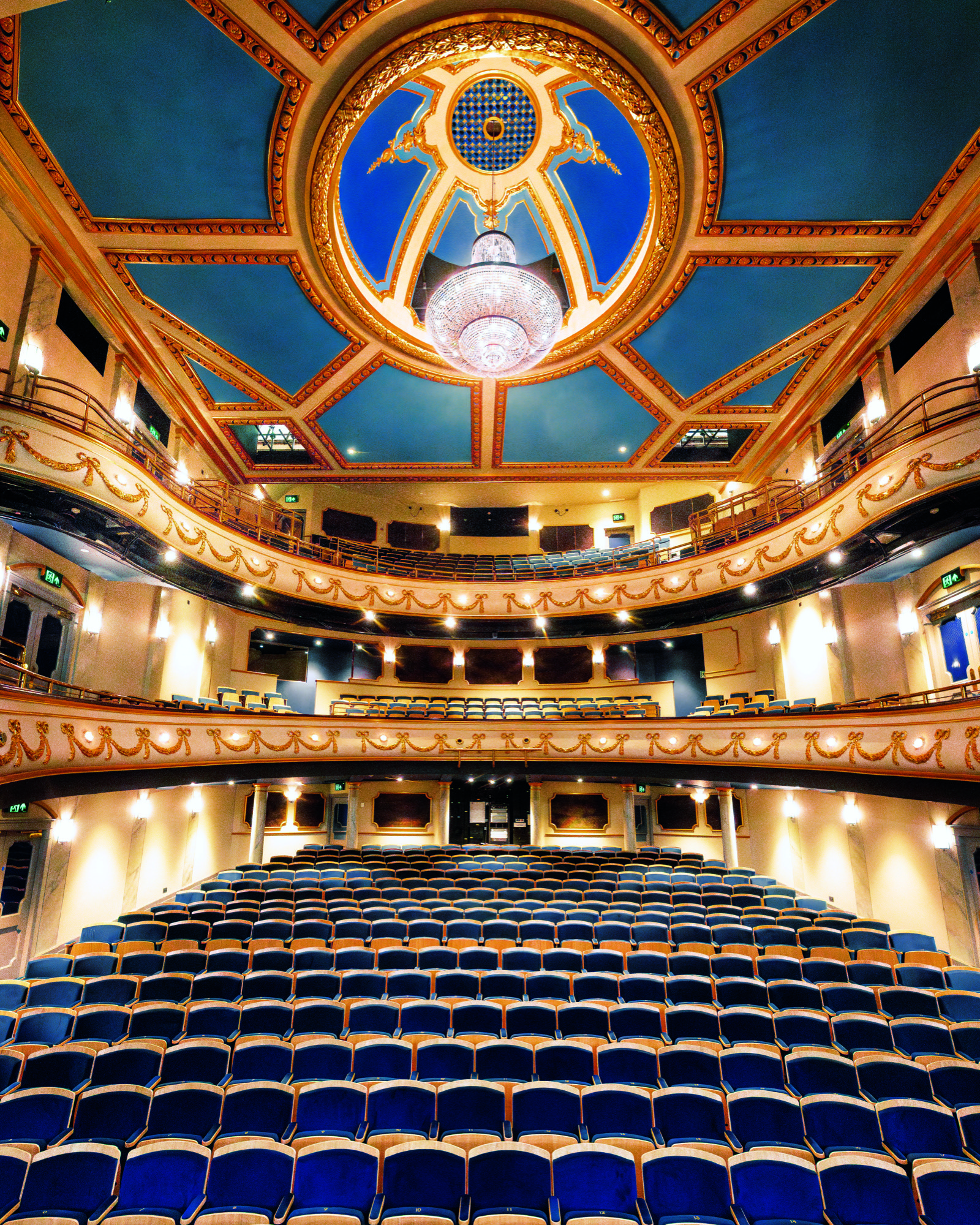A view of the new auditorium, with blue seats, a blue ceiling and lots of gold and reds