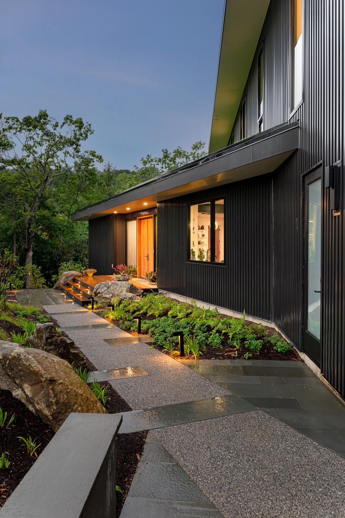 A garden path with spotlights and lighting illuminating the porch area