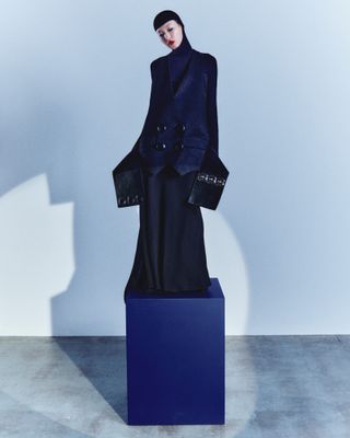 Woman standing on plinth in Louis Vuitton dress