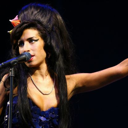 Amy Winehouse singing on stage.