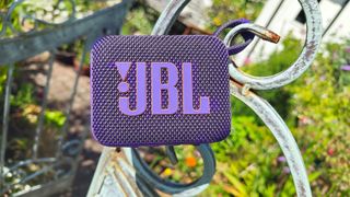 JBL Go 4 Bluetooth speaker hooked onto garden chair