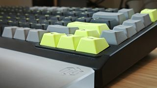A black and green NuPhy Field75 keyboard on a wooden desk