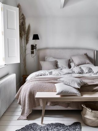 White bedroom with rustic decor and white and grey bedding