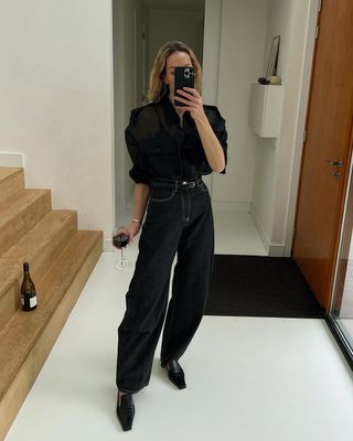 @anoukyve wearing barrel leg jeans with a sheer shirt