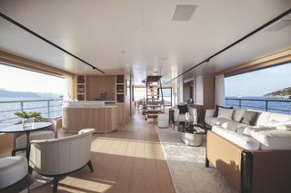 View of the upper deck interior of the Benetti B.Yond yacht with the Urban sofa and armchair on the right, and the Aura armchairs and Oti table on the left.