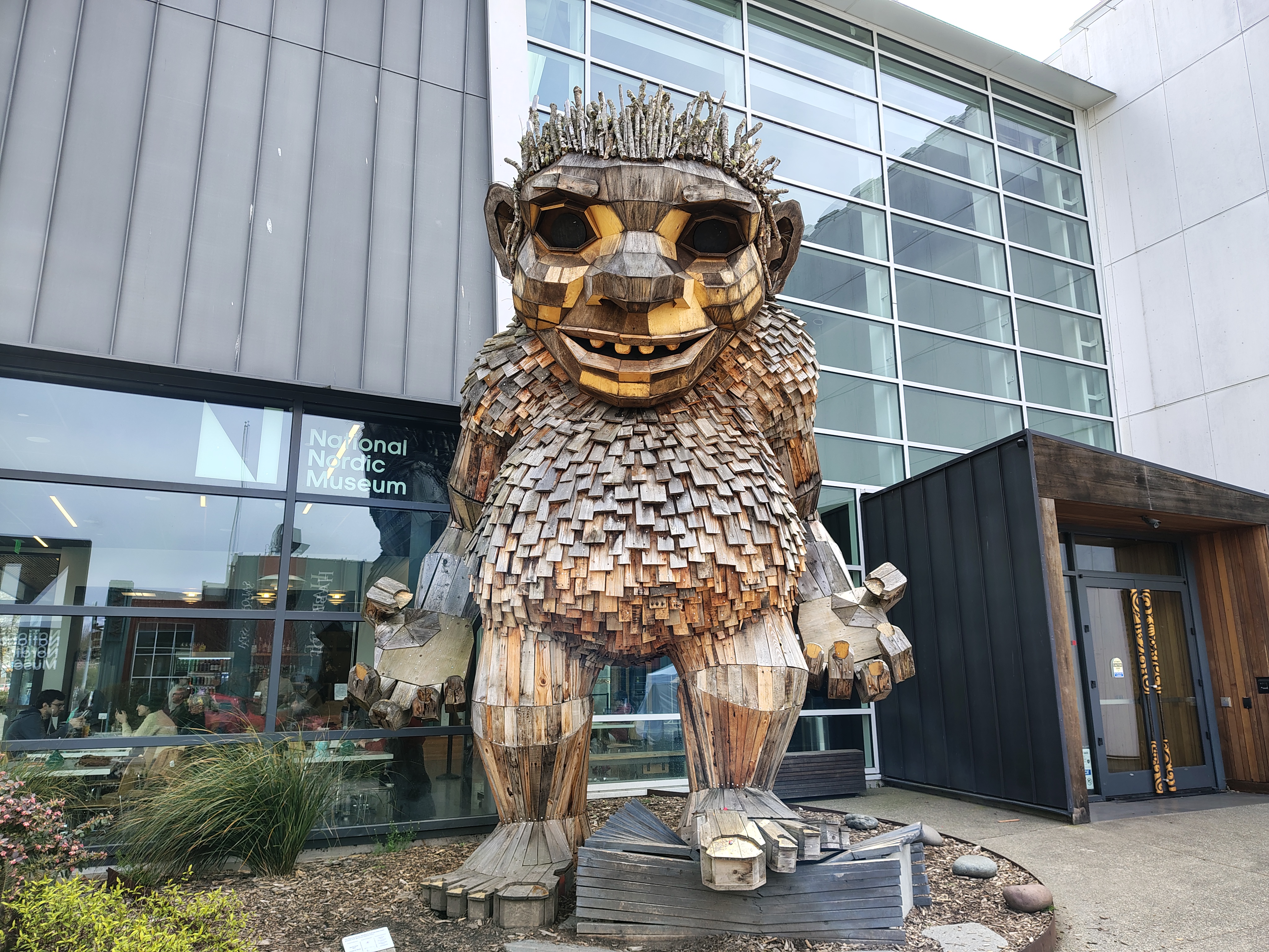 A large wooden troll statue in front of a building