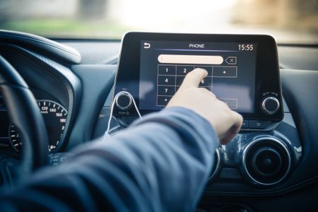 Young Man Reading Messages And Make Phone Call While Driving