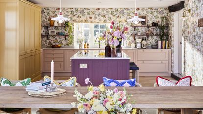 Sophie Robinson&#039;s Magnet kitchen with red island, yellow and pink cabinets.