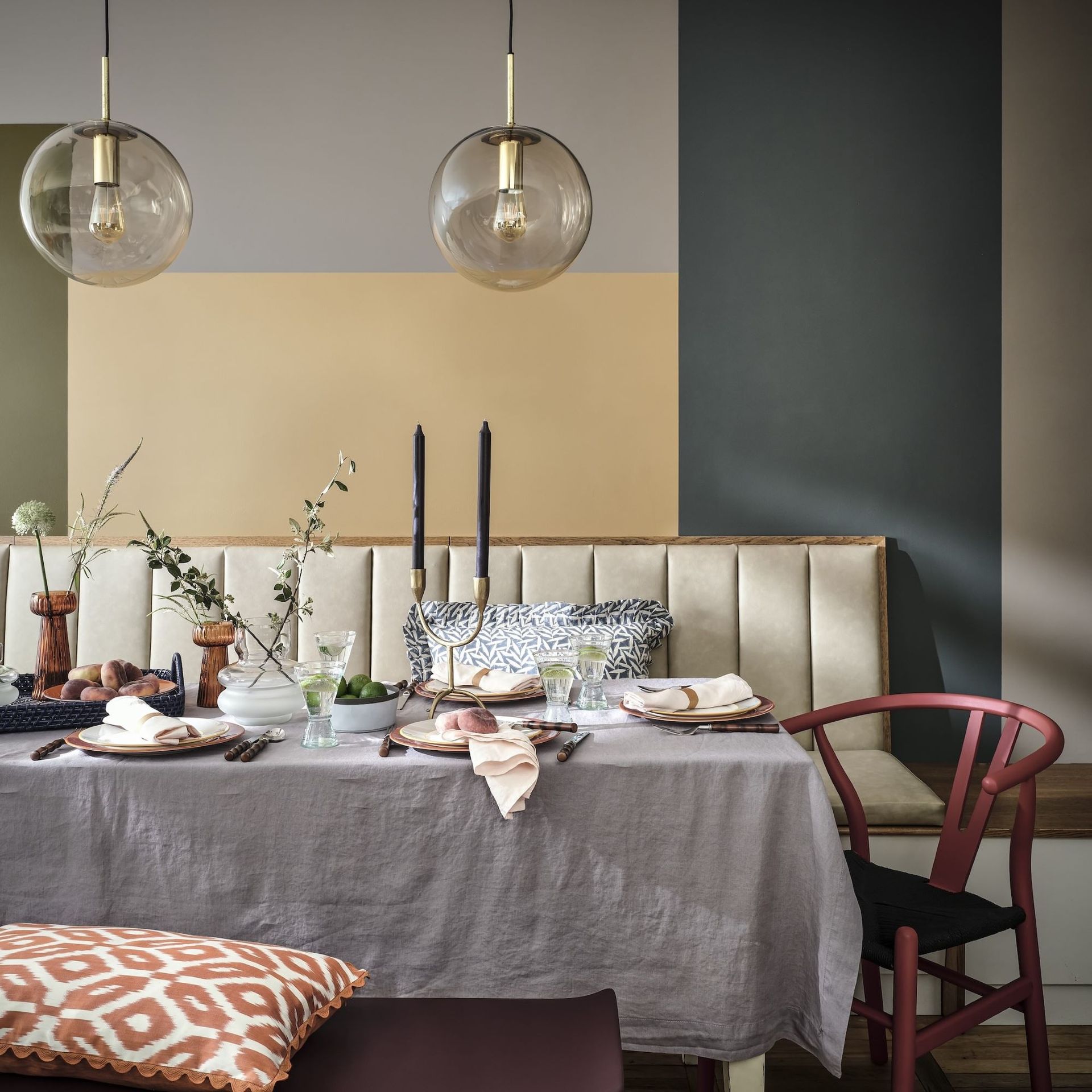 dining table with white tablecloth in front of yellow, blue and grey wall