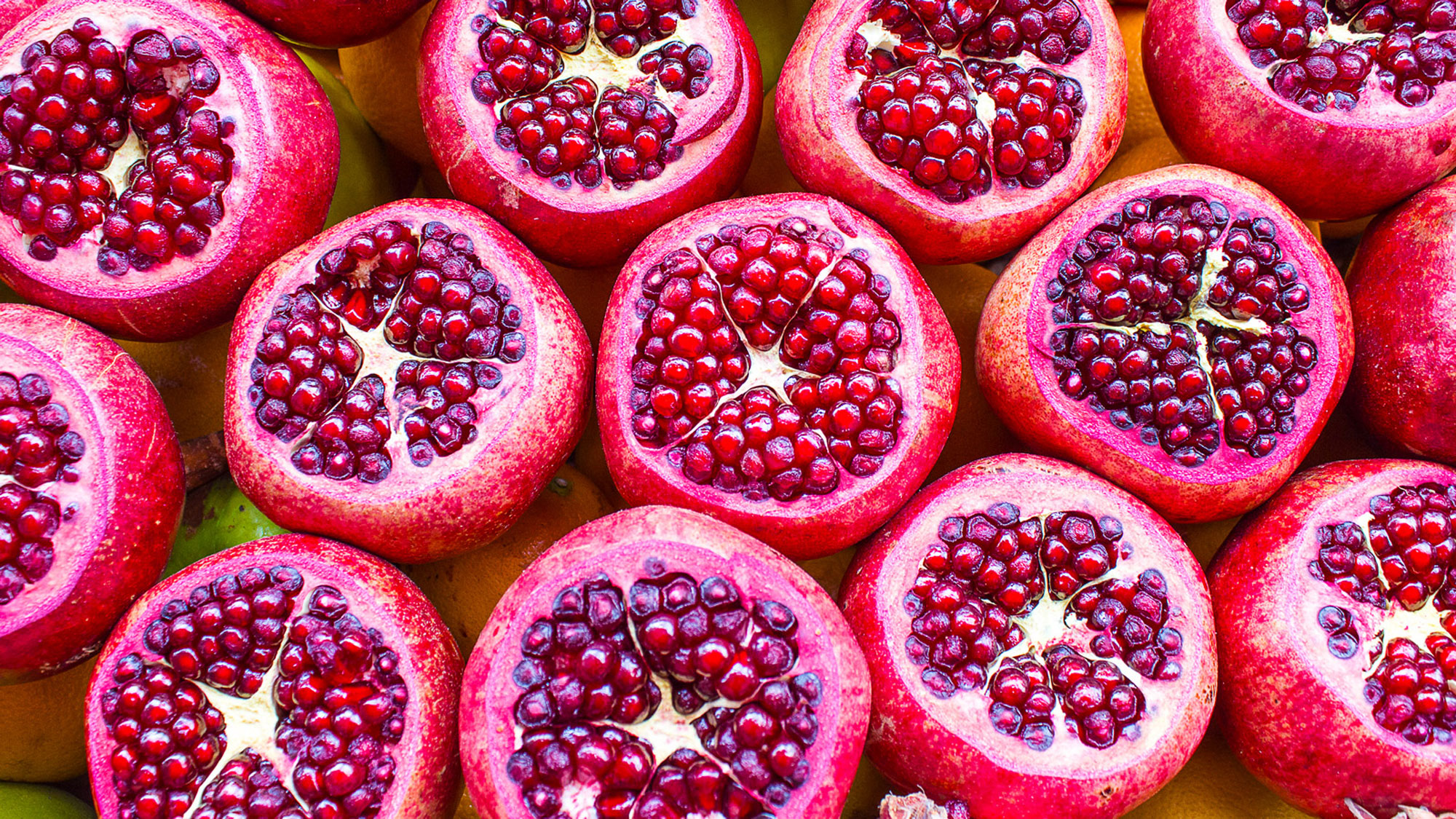 ripe red pomegrante fruits sliced and splashed in water