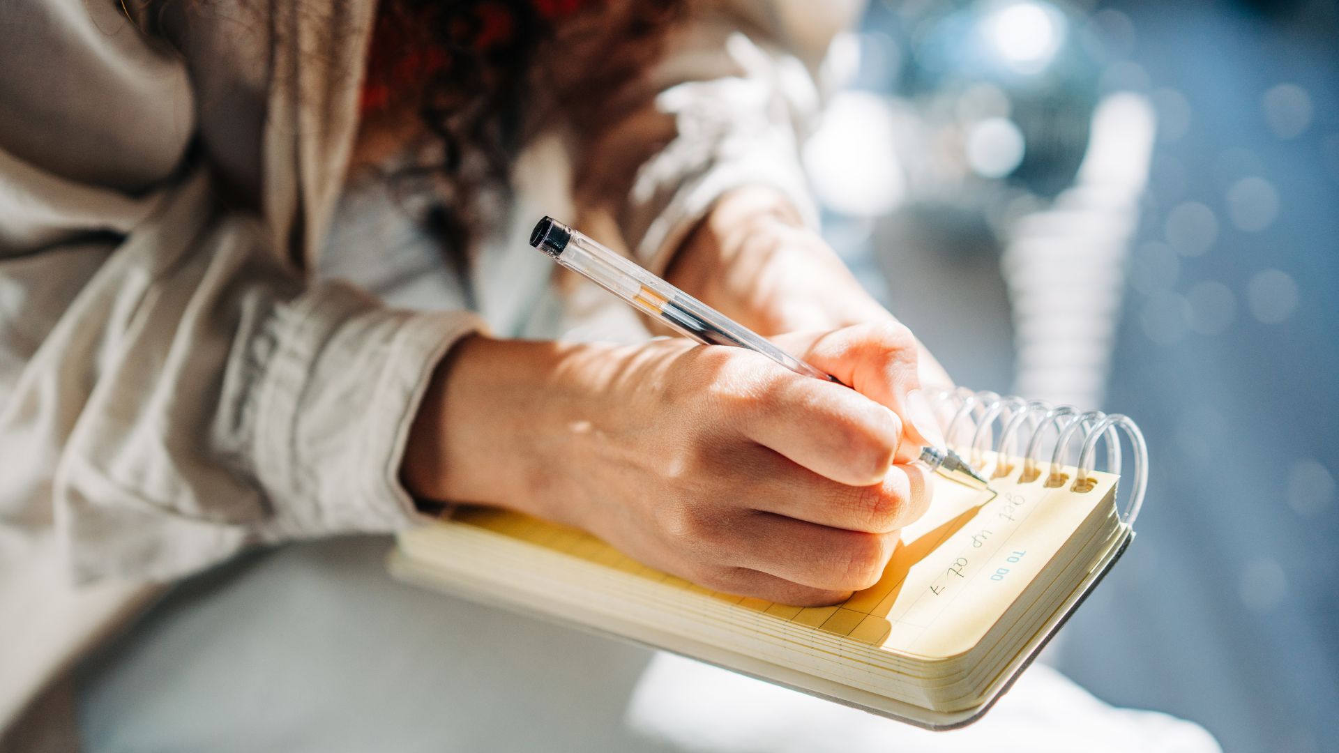 picture of woman writing down to do list in notepad