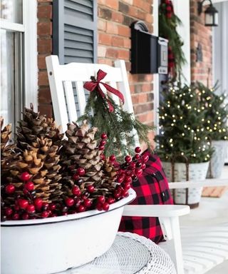 Christmas porch decor with wreath tree and decorative bowl of pinecones and berries