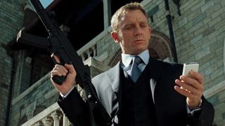 Daniel Craig checks his phone while armed in Casino Royale.