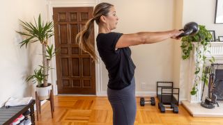 Woman performing a kettlebell swing at home