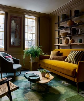 living room with ochre velvet sofa and green rug