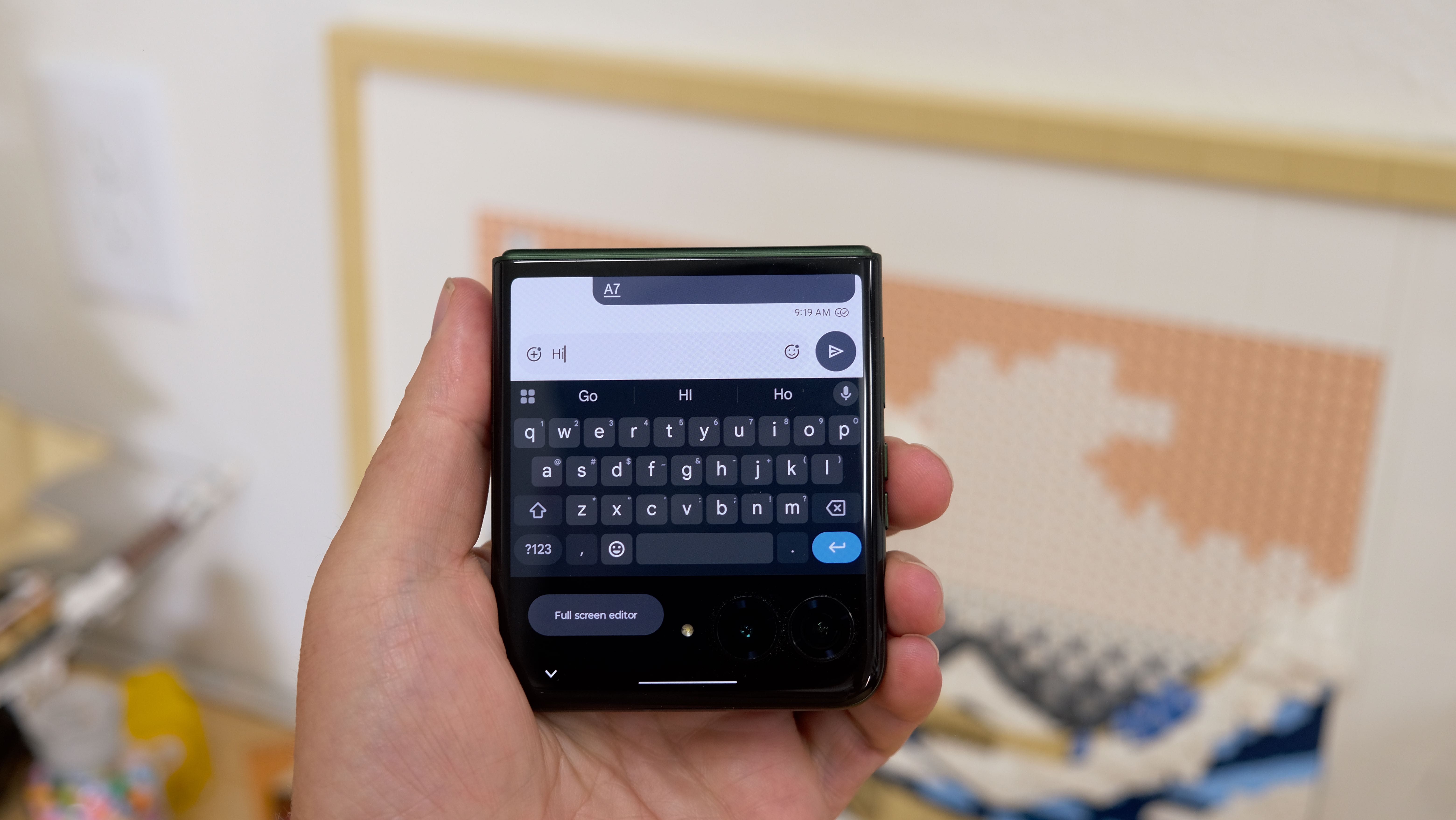 The Motorola Razr Plus 2026 in the hand and on a wooden table