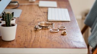 silver rings and bracelets on a wooden desk