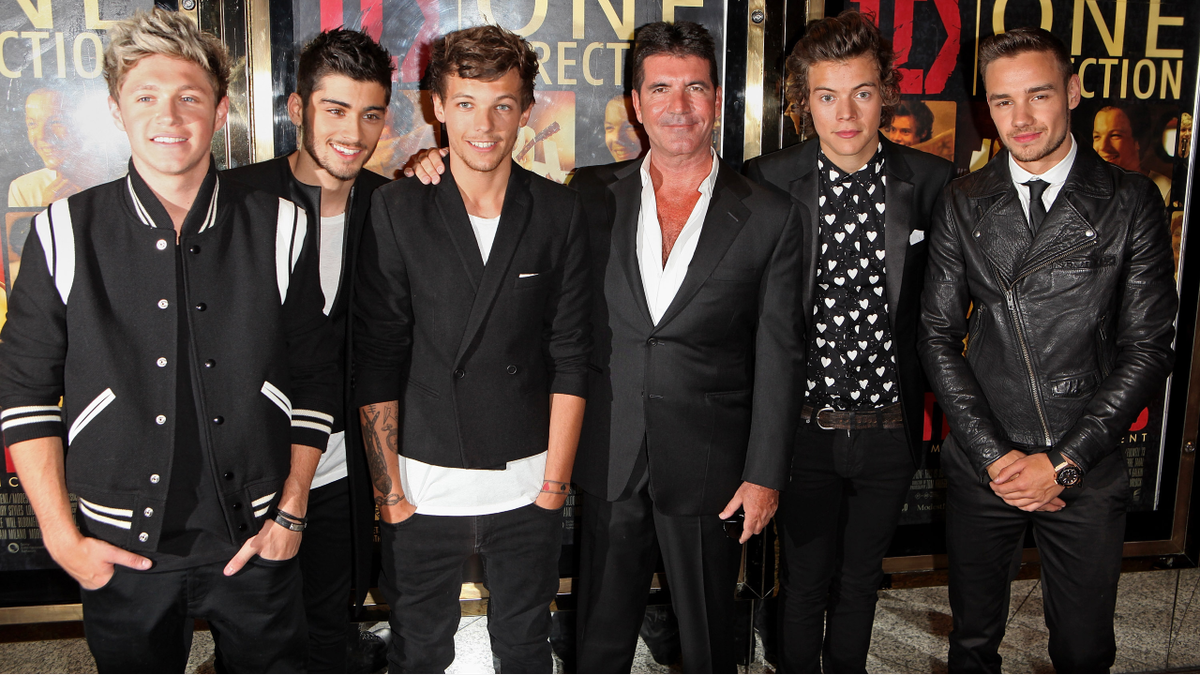  (L to R) Niall Horan, Zayn Malik, Louis Tomlinson, Simon Cowell, Harry Styles and Liam Payne smiling and standing together at the World Premiere of &#039;One Direction: This Is Us 3D&#039; at Empire Leicester Square on August 20, 2013 in London, England.