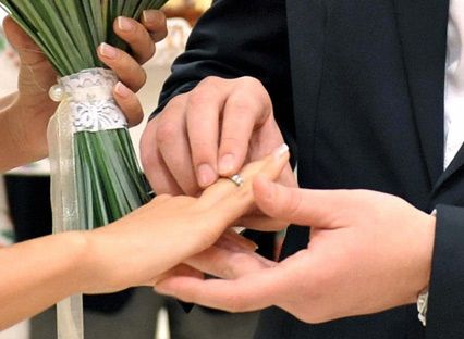 A couple exchange wedding rings 