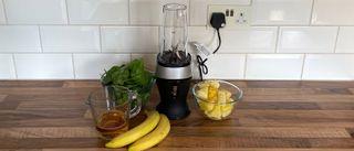 Ninja Personal Blender and Smoothie Maker QB3001 on a kitchen countertop surrounded by bowls of fruit and vegetables