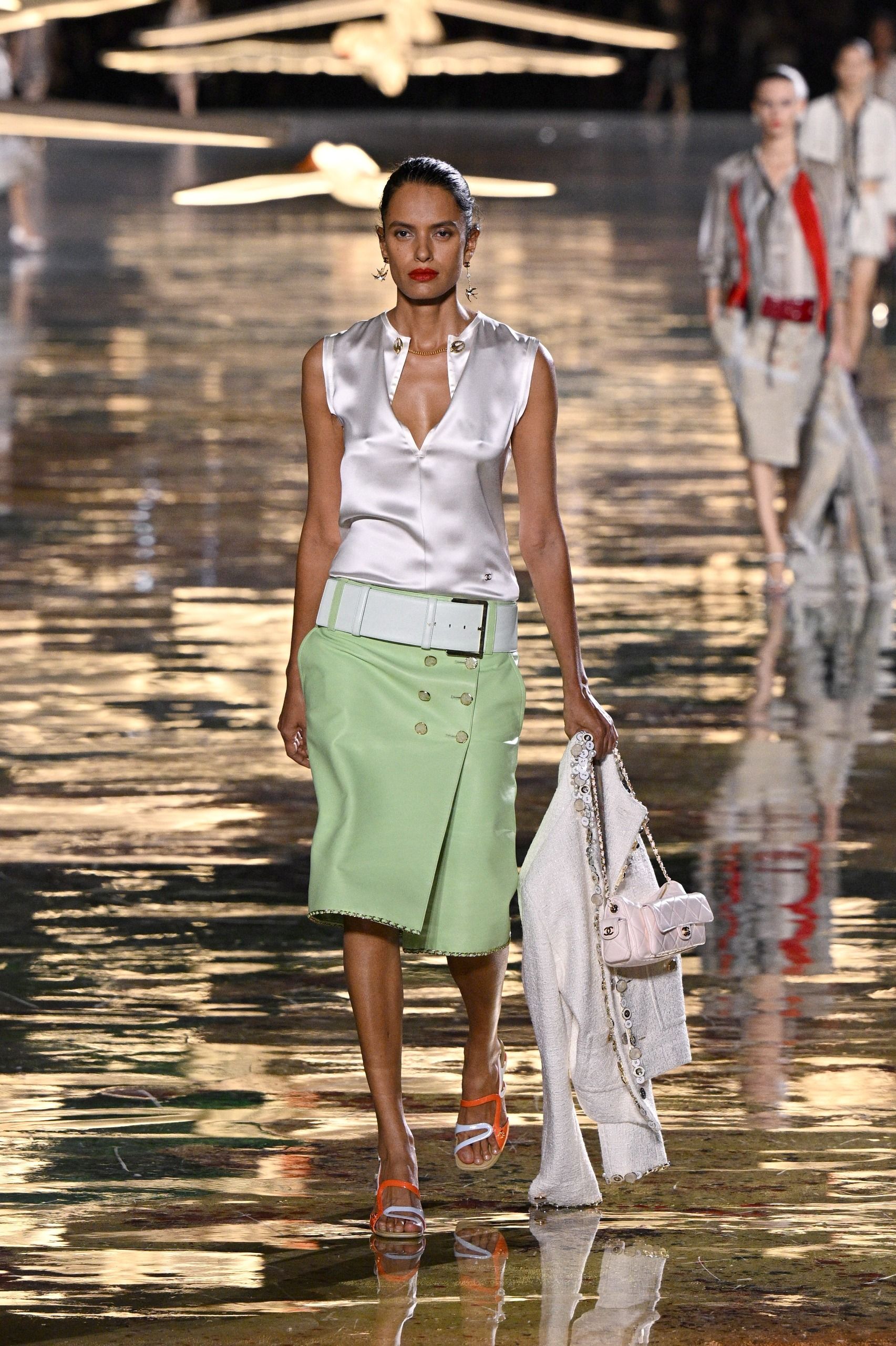a model on a catwalk dressed in mint green clothes