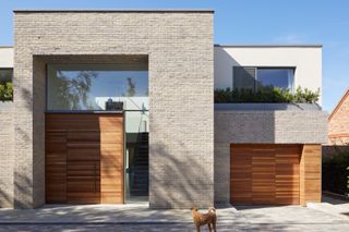 Frontage of modern home with wooden door and garage