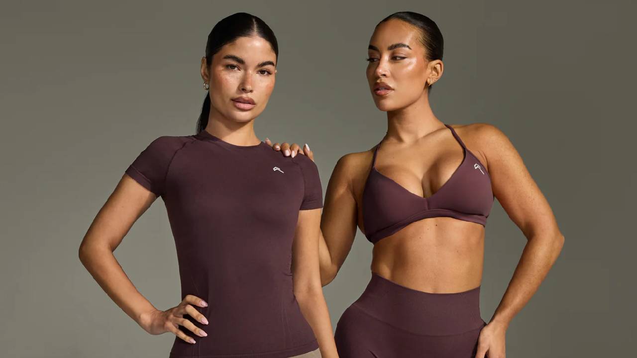Two female models wearing matching burgundy workout sets from Oner Active.