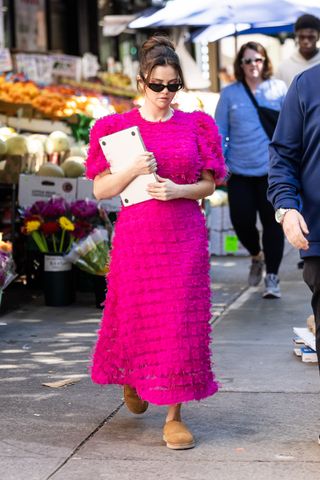 Selena Gomez wearing a pink dress and Uggs on set for Only Murders in the Building in New York City