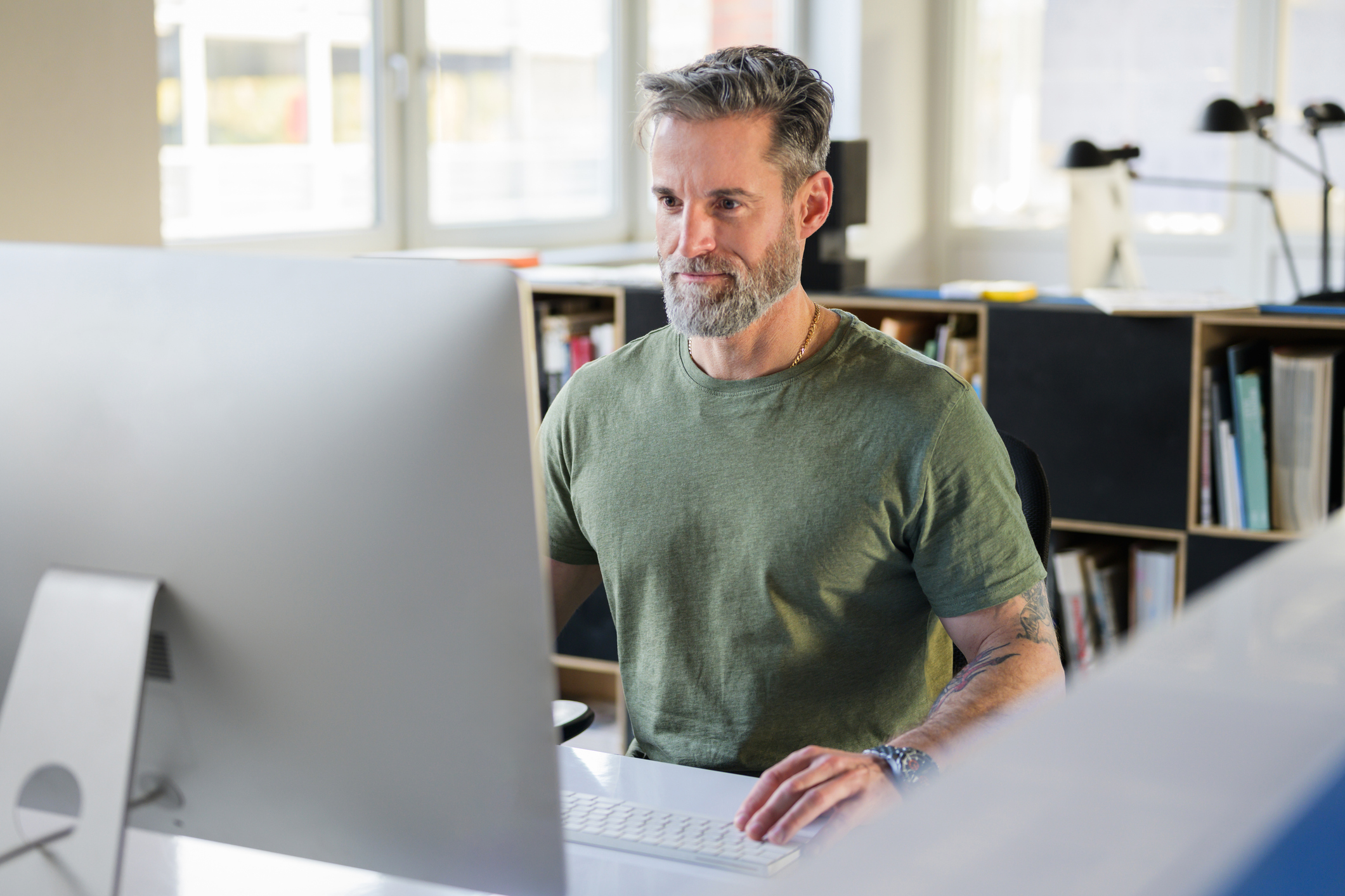 A man working at a computer in a bright office space.