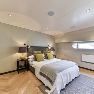 houseboat bedroom with wooden floor and bed near lamp