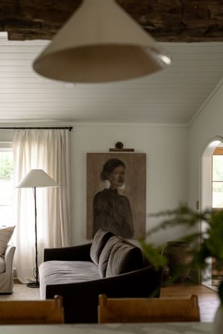 a living room with a gray couch and an artwork of a woman