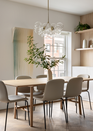 A minimal dining room with a vase of leafy stems