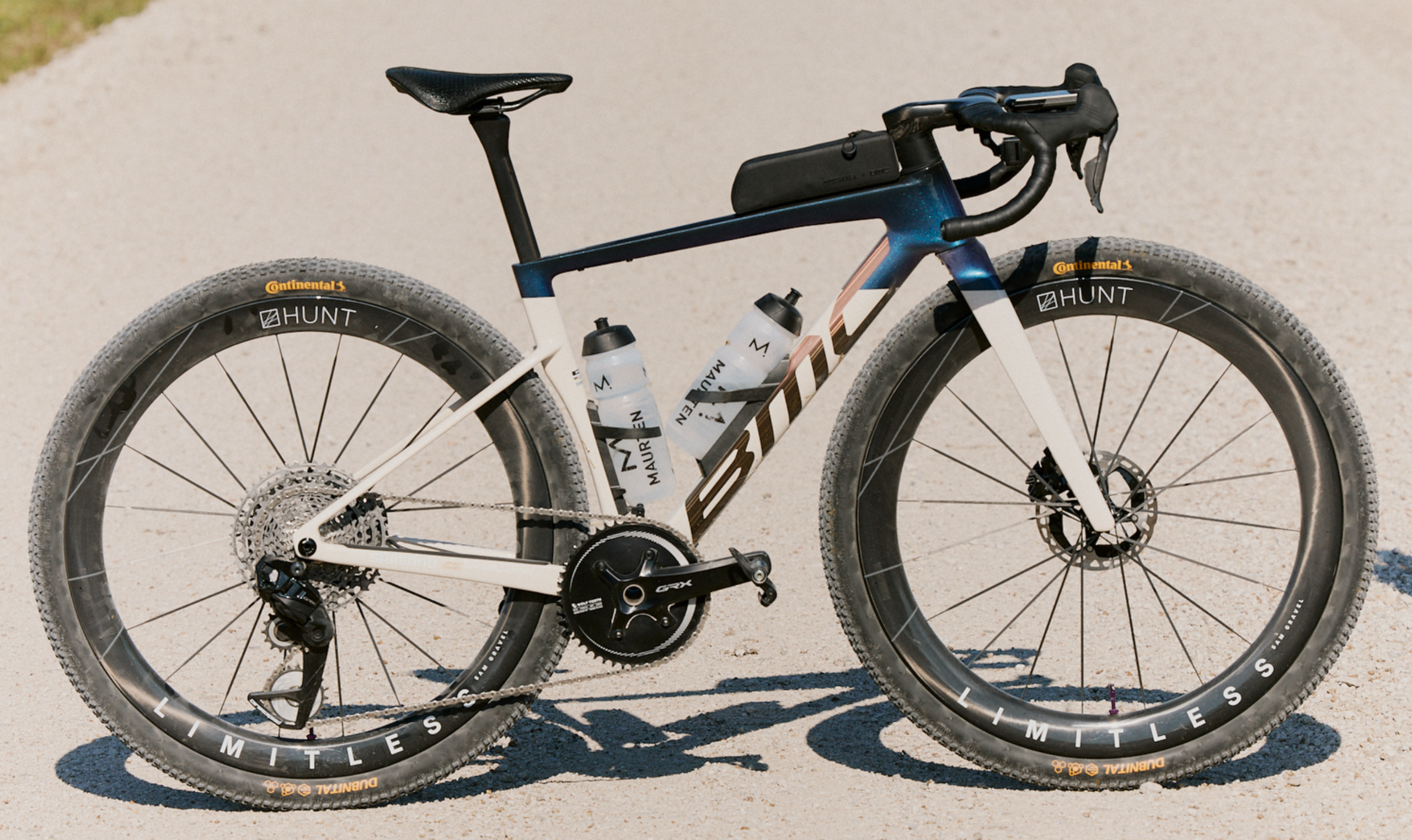 Blue and white BMC gravel bike with Hunt deep section carbon wheels on a road
