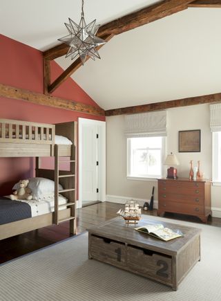 traditional bedroom with white ceiling brown beams and furniture and red feature wall