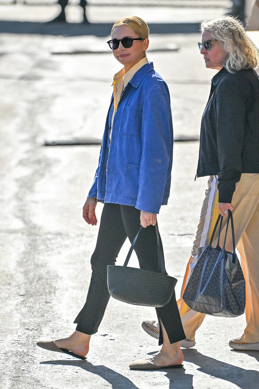 Michelle Williams wearing a blue chore coat, yellow shirt, black skinny pants, and slipper mules in L.A.