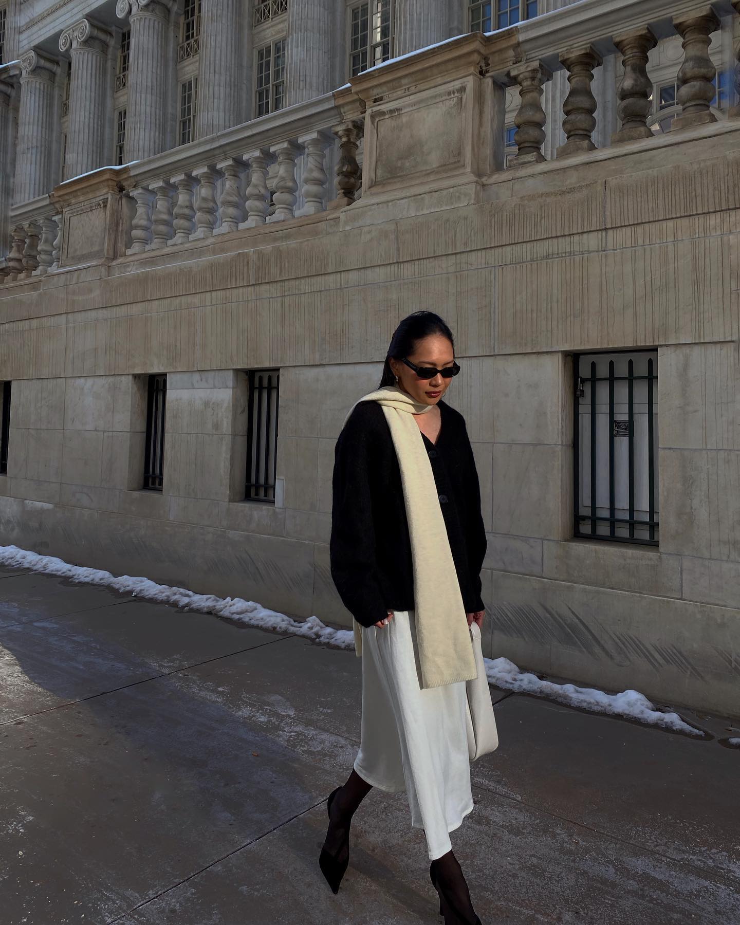 Dawn Tan wearing a cashmere scarf, black jumper and white skirt