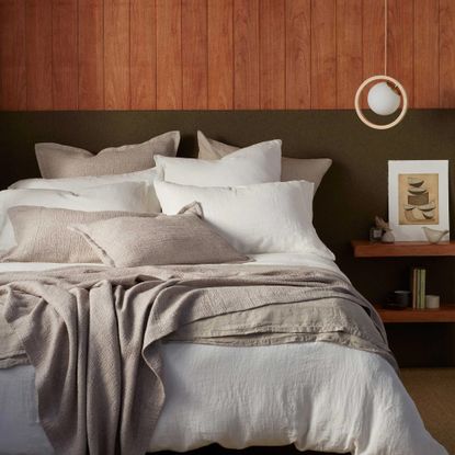 A bed with six or seven pillows on from the Secret Linen Store