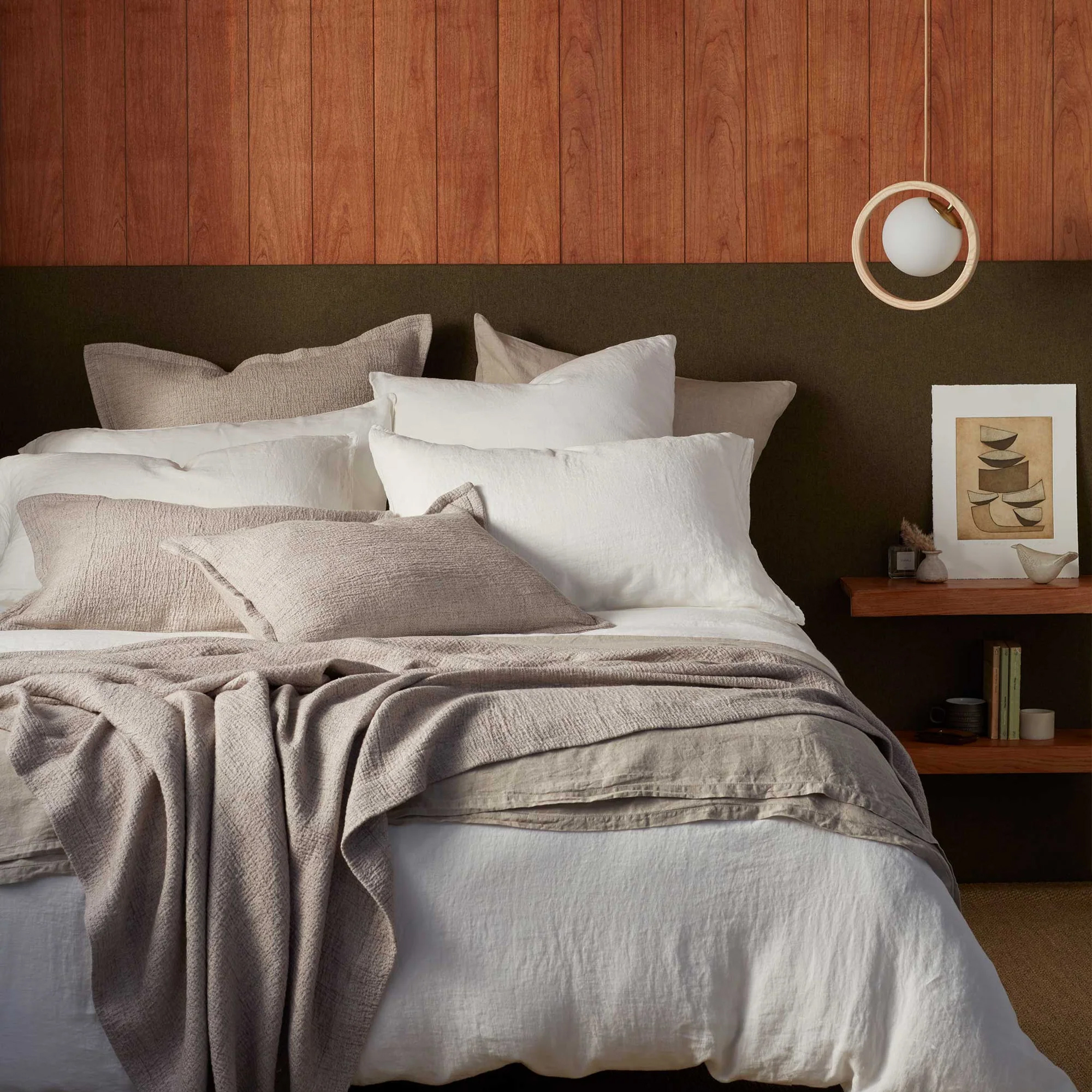 A bed with six or seven pillows on from the Secret Linen Store