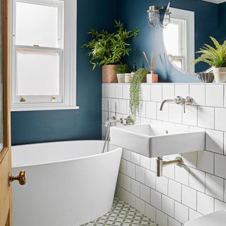 bathroom with blue and white tiles wall white window bathtub and wash basin