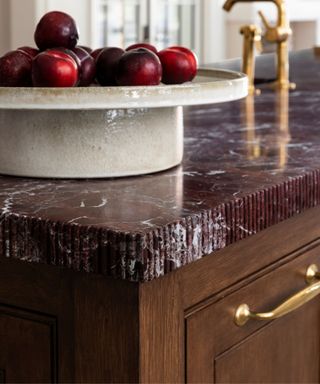 A dark marble kitchen countertop with a fluted edge detail