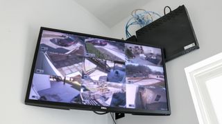A monitor connected to a Reolink NVR showing a number of feeds from various security cameras