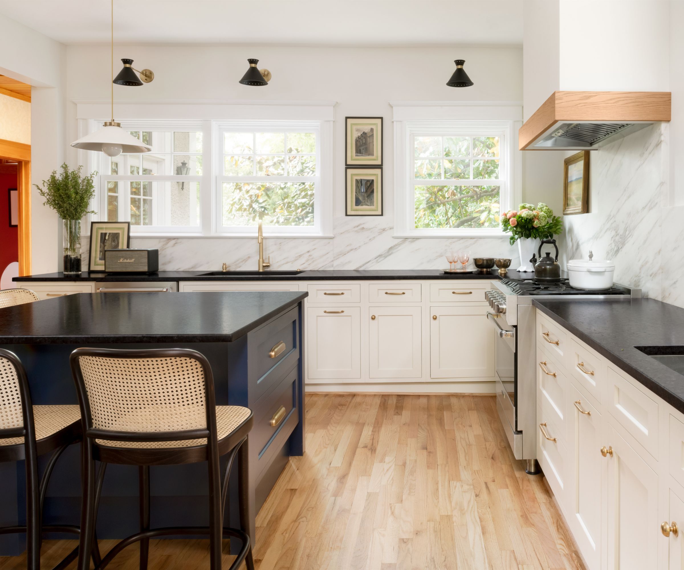 A black and white kitchen with a layered lighting scheme